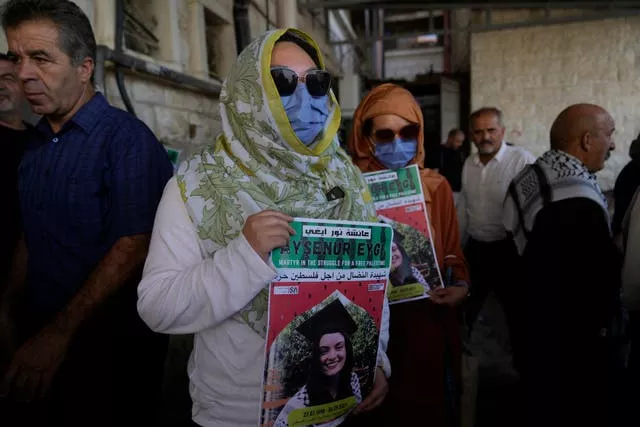 Two fellow activists of Aysenur Ezgi Eygi carry posters with her name and photo during Ms Eygi’s funeral procession in the West Bank city of Nablus