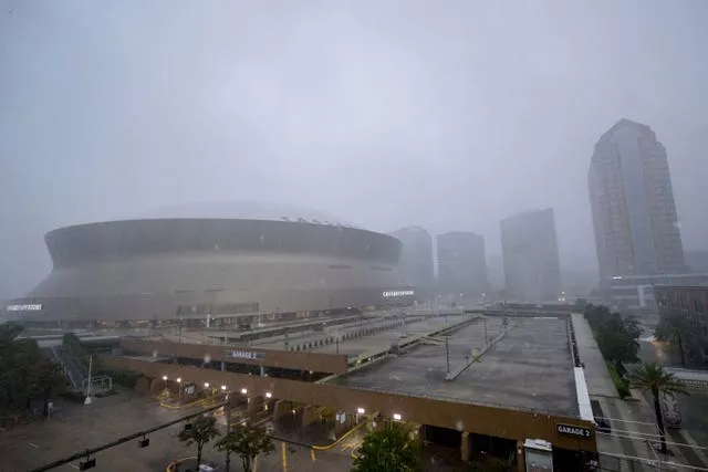 Rainfall from Hurricane Francine makes the white roof of the Caesars Superdome, left, difficult to see in New Orleans