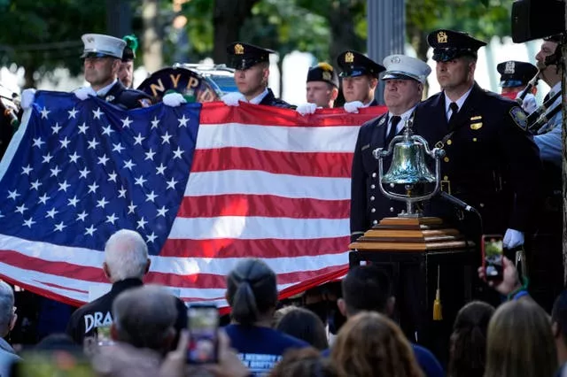 A New York Police Department honour guard holds an American flag 