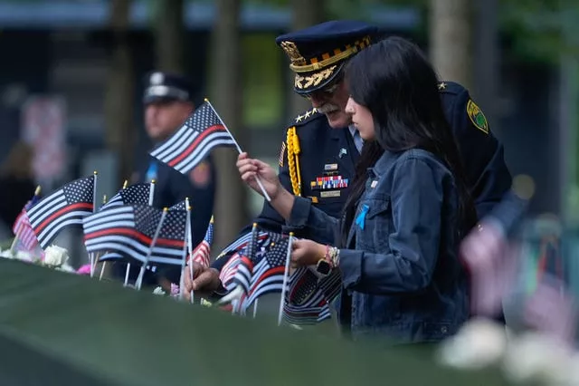 A police chief places flags of remembrance on the memorial