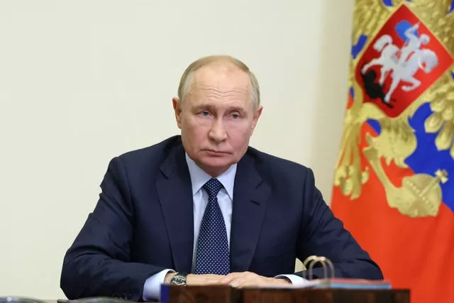 Russian President Vladimir Putin sat at a desk