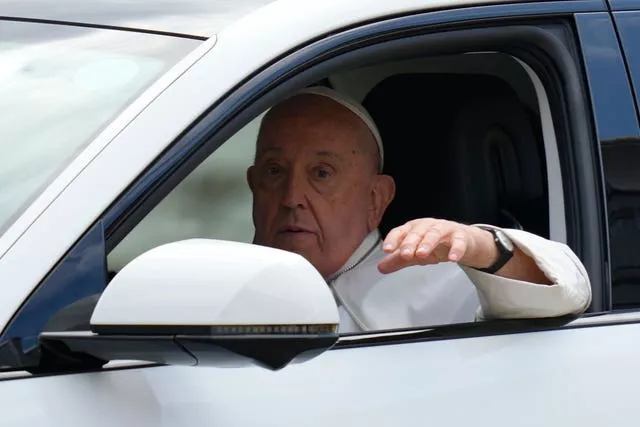 Pope Francis waves from the car