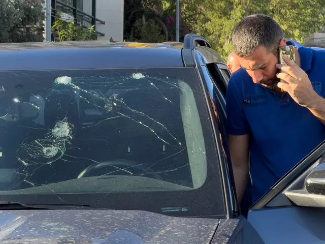 A police officer inspects a car in which a hand-held pager exploded