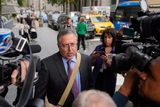 Man surrounded by press with cameras