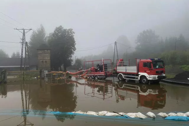 Polish firefighters pump water and mud from city streets