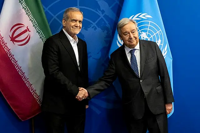 President of Iran Masoud Pezeshkian, left, and UN Secretary-General Antonio Guterres shake hands