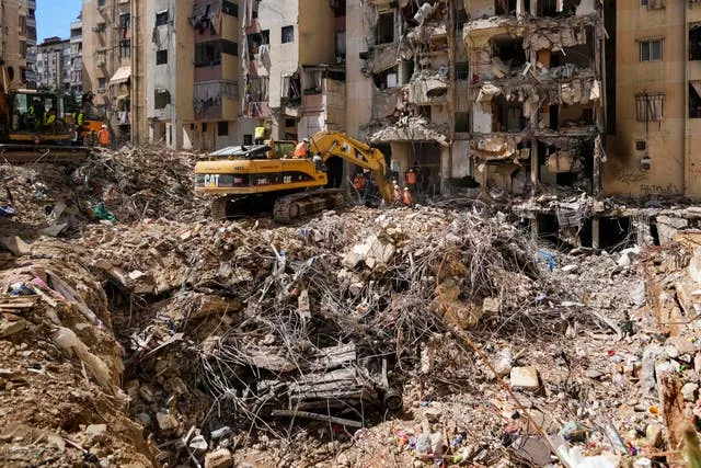 Rescuers sift through the rubble as they search for people still missing at the site of Friday’s Israeli strike in Beirut’s southern suburbs