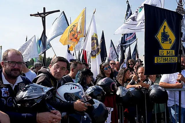 Motorcyclists holding their helmets and their groups’ banners gather at the Roman Catholic holy shrine of Fatima to attend the IX Pilgrimage of the Blessing of Helmets that draws tens of thousands, in Fatima, Portugal