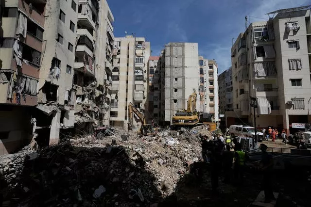 Emergency workers clear the rubble at the site of Friday’s Israeli strike in Beirut’s southern suburb 