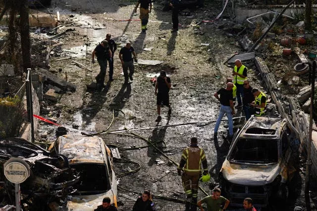 Israeli security forces examine the site hit by a rocket