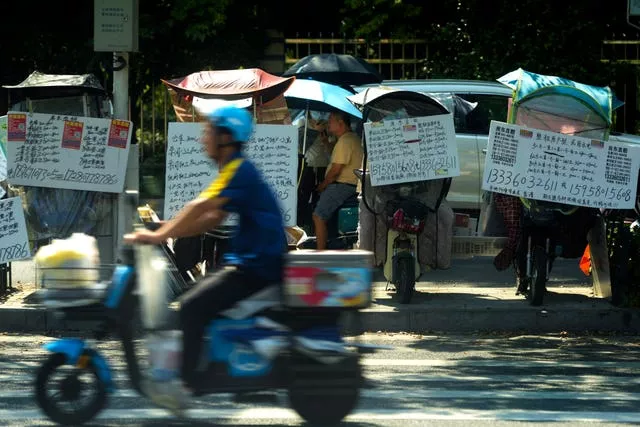 A motorist passes by placards showing properties for lease in China