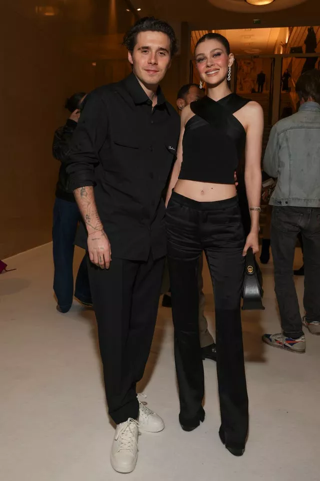 Brooklyn Beckham, left, and Nicola Peltz attend the Balmain Spring/Summer 2025 collection 