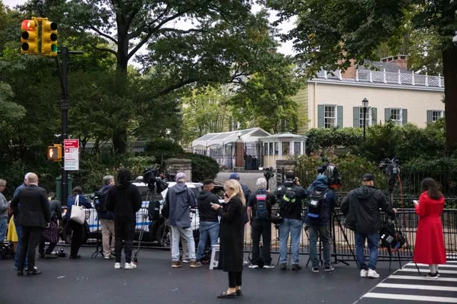 Members of the media gather outside Gracie Mansion, the official residence of New York City mayor Eric Adams, in New York