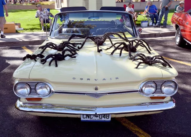 A classic car decorated with fake spiders