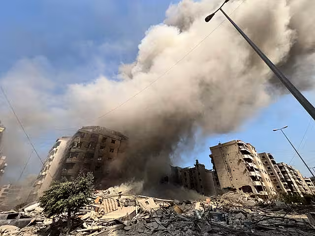 Smoke rises as a building collapses in Beirut’s southern suburbs