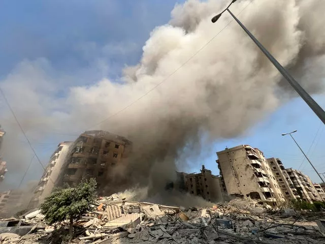 Smoke rises as a building collapses in Beirut’s southern suburbs