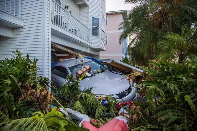 A vehicle sits outside of its garage after storm surge