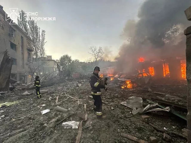 Firefighters tackling building blaze, surrounded by debris