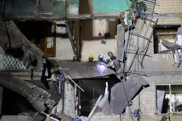 Rescue workers clear rubble from a building damaged by a Russian airstrike in Kharkiv