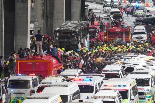 Rescuers gather at the site of the bus fire 