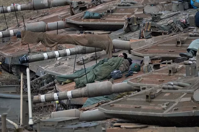 Israeli soldiers sleep on tanks in a staging area in northern Israel near the Israel-Lebanon border 