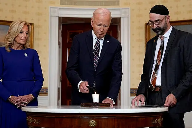 Joe Biden, with first lady Jill Biden and Rabbi Aaron Alexander, lighting a memorial candle