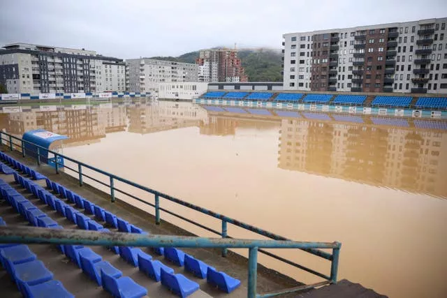 Apartment buildings are reflected at a flooded football field after heavy rain in the village of Kiseljak, northern Bosnia