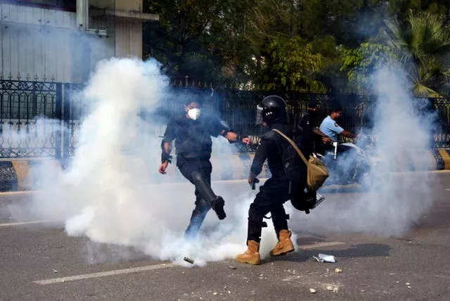 Two people surrounded by tear gas