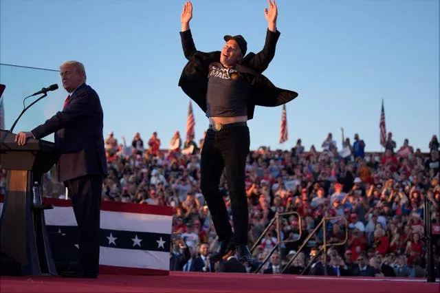 Elon Musk jumps on the stage alongside Donald Trump