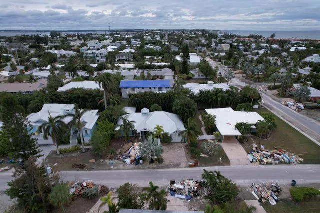 Piles of furniture and household items destroyed in Hurricane Helene flooding sit piled up outside of homes ahead of the arrival of Hurricane Milton