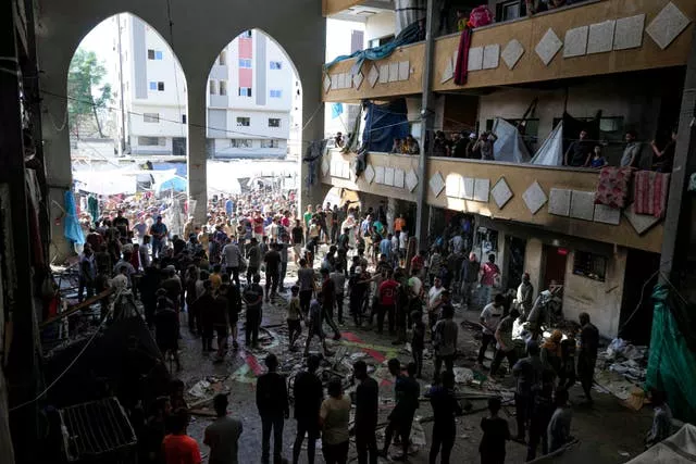 Palestinians inspect the damage of a school hit by an Israeli bombardment on Deir al-Balah, central Gaza Strip