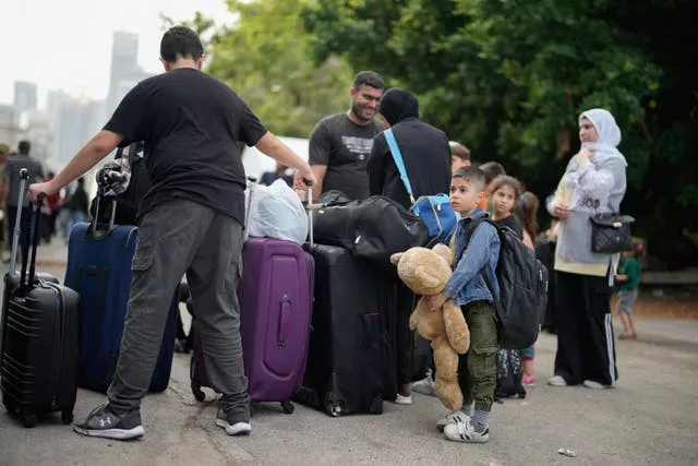 People wait to board a military ship evacuating them from Lebanon to Turkey