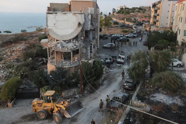 Lebanese army soldiers deploy around a building hit by an Israeli airstrike