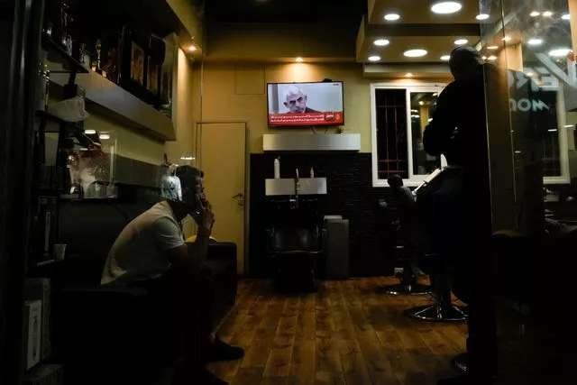 A photo of Hamas leader Yahya Sinwar is displayed on a TV screen at a barbershop in the West Bank city of Bethlehem