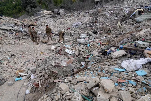 Lebanese army soldiers search in the rubble of a destroyed building