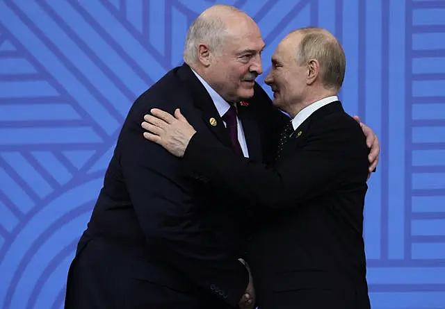 Russian President Vladimir Putin embracing Belarusian President Alexander Lukashenko