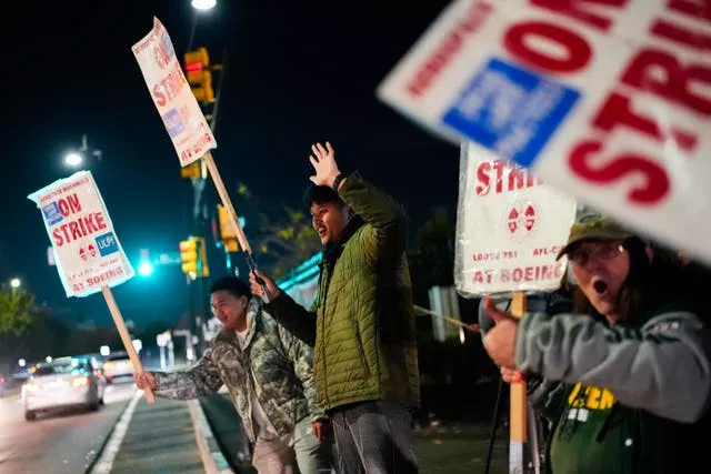 Boeing employees, including assembler Tyrone Hipolito, centre, work the picket line 