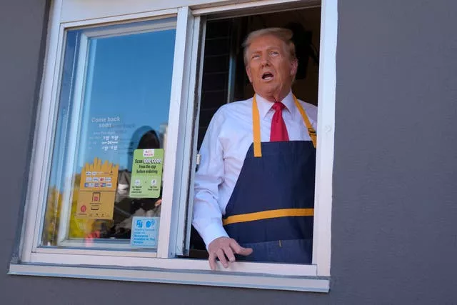 Donald Trump stands at a window