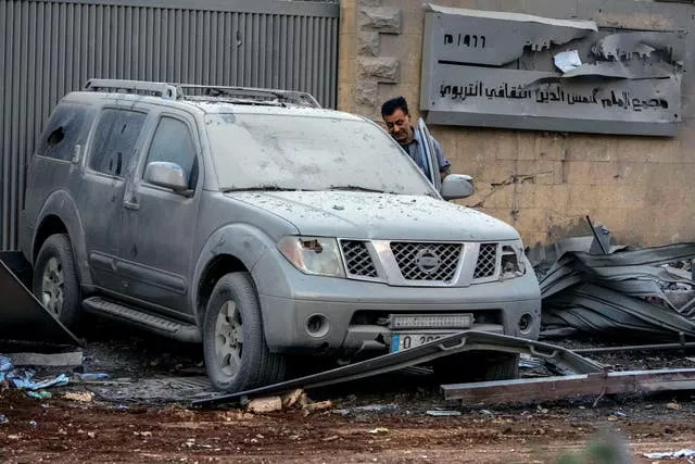 A man inspects a wrecked car 