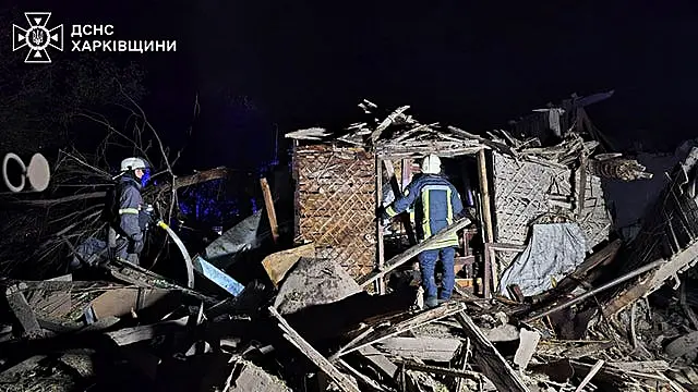 Rescue workers clear the rubble of a house destroyed by a Russian strike in Kharkiv