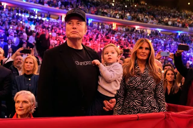 Elon Musk and Melania Trump listen as Donald Trump speaks at a campaign rally