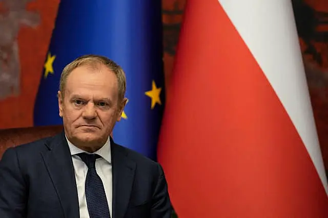 Donald Tusk sat before national flags