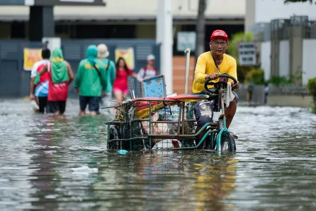 People fight their way through floodwaters