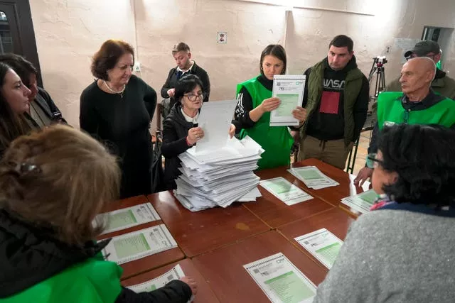 Members of an election commission count ballots at a polling station after the parliamentary election in Tbilisi, Georgia