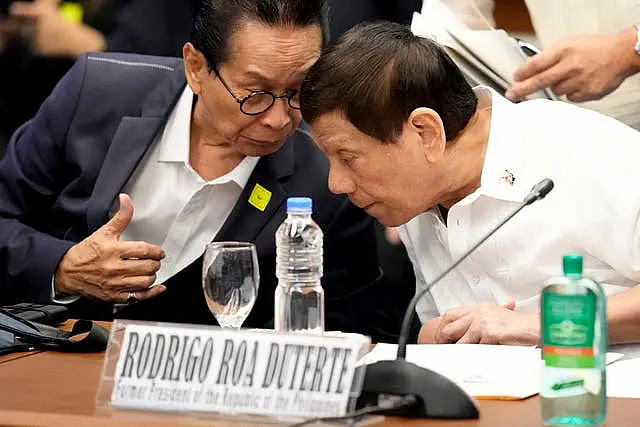 Mr Duterte leans over to speak to a representative