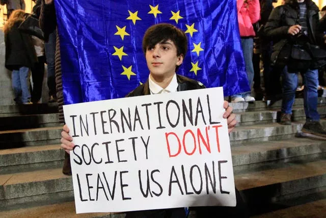 A man holds a poster during an opposition protest in Georgia