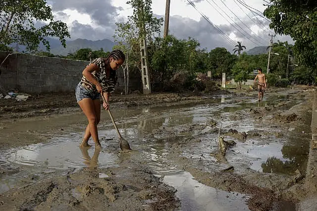 People try to remove mud from a street a week after Hurricane Oscar hit the town of Imias in Guantanamo province 