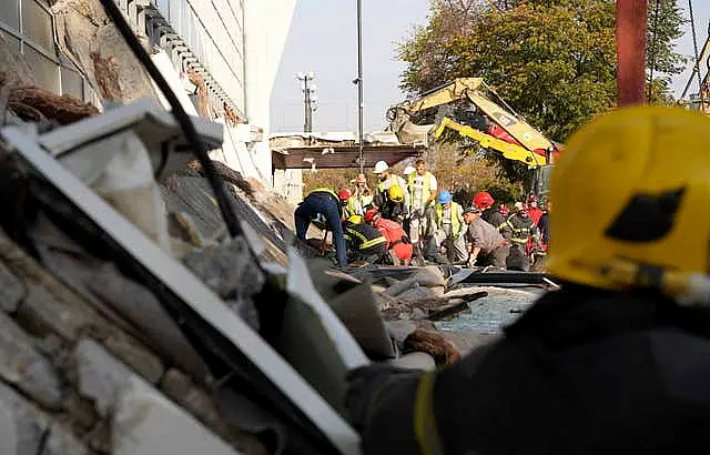 Rescue service staff work at the scene of the collapse