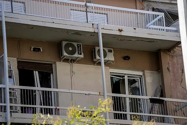 Broken windows are seen on a damaged apartment following an explosion