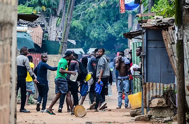 Protesters recover from tear gas fired by police in Maputo